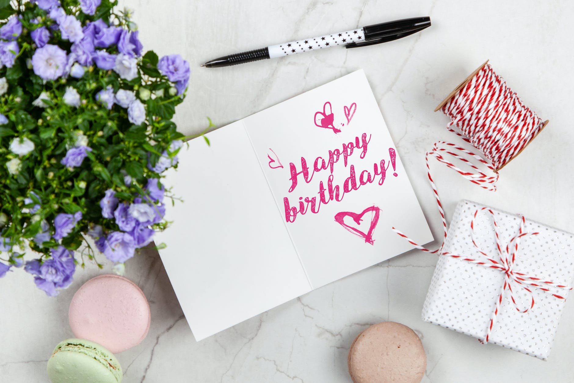 happy birthday card beside flower thread box and macaroons