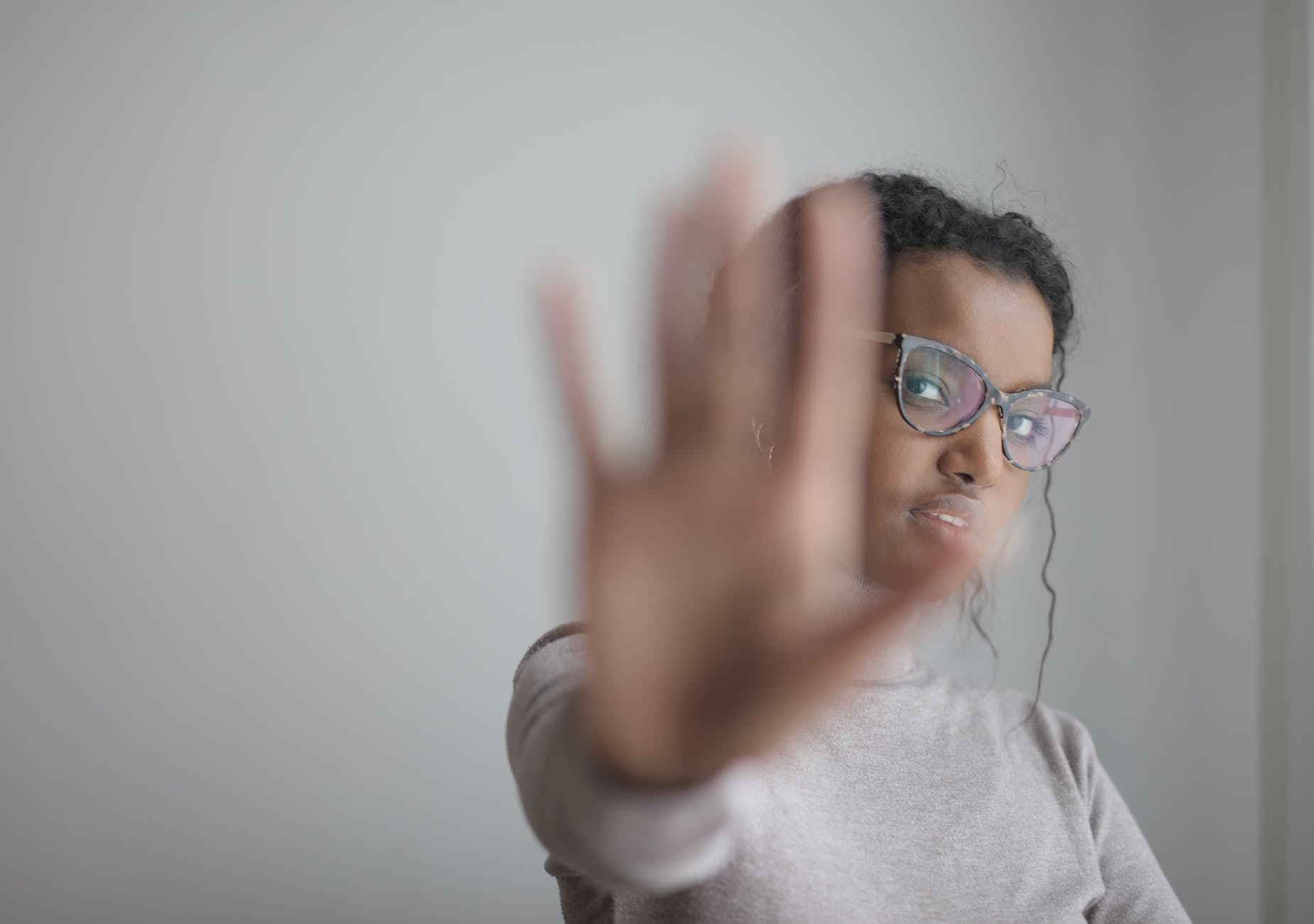 ethnic woman doing stop gesture with palm at camera